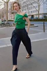 Pantalón tipo culotte de tiro alto confeccionado en denim azul oscuro. Presenta pinzas delanteras, pernera ancha y corta, bolsillos laterales ocultos y cierre frontal con cremallera, botón y ganchos.