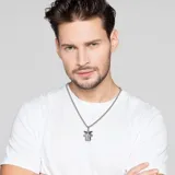 Collar plateado con dije de Baby Yoda, personaje de Star Wars. La cadena es de acero inoxidable y el dije tiene detalles en negro. Producto oficial de Disney.