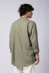 Camisa de manga larga confeccionada en lino, color verde oliva, con cuello clásico y cierre frontal de botones.