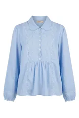 Camisa celeste de manga larga con cuello bebé, detalles de encaje y bordados en el frente, y cierre frontal con botones.