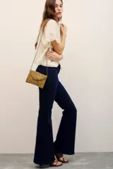 Pantalón de jean azul oscuro tiro alto, de corte flared con botamanga acampanada.