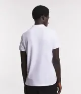 Polo de hombre slim fit color beige, confeccionada en tejido de media malla acanalada de algodón sostenible, con cuello clásico con botones y mangas cortas.