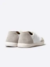 Zapatillas bajas de cuero blanco con puntera y talón de gamuza color beige.