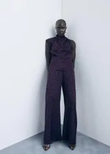 Pantalón de tiro medio con diseño flare y largo, con cierre de cremallera lateral y estampado de lunares.