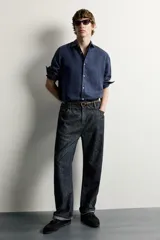 Mocasines de vestir para hombre confeccionados en piel con acabado en serraje de color azul marino, con detalle de borlas en el empeine y suela con ligero tacón.