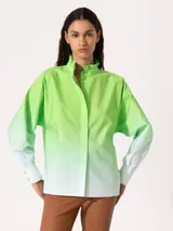 Camisa verde lima con degradé a blanco, de corte holgado, cuello mao con volantes y mangas largas con puños abotonados.