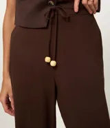 Pantalón de corte recto confeccionado en mezcla de viscosa y lino. Presenta cintura elástica con cordón ajustable y bolsillos laterales.
