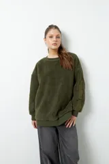 Buzo negro de tela tipo teddy, de manga larga y cuello redondo. Presenta recortes de nylon en mangas y laterales.