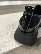 Zapato tipo mocasín color peltre con detalle de costuras en contraste y suela track color negro.