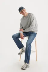 Jeans de corte regular fit en color azul medio, con diseño clásico de cinco bolsillos y cierre frontal con botón y cremallera.