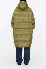 Plumífero largo negro con guateado horizontal, relleno de plumón y pluma. Corte recto, cuello alto con capucha y cierre frontal con cremallera y solapa. Bolsillos frontales ocultos, puños fruncidos con elástico y logo bordado en la espalda.