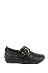 Zapato bajo de cuero negro con diseño artesanal, hebilla lateral metálica dorada y costuras decorativas.
