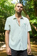 Camisa de manga corta con estampado de líneas verdes sobre fondo blanco, confeccionada en tela crepé.