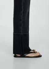 Jeans de corte recto y tiro medio en color negro lavado. Presentan diseño de cinco bolsillos, cierre frontal con cremallera y botón, y un distintivo bajo con vuelta ancha.