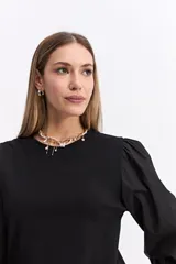 Remera de algodón con cuerpo liso y mangas largas abullonadas en popelina, con puños elásticos fruncidos.