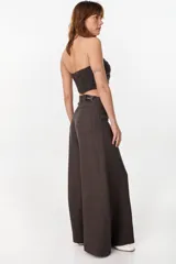 Pantalón de lino verde militar, de tiro alto y corte amplio con botamanga ancha. Cuenta con bolsillos delanteros aplicados y cierre frontal con botón y bragueta.