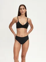 Conjunto de ropa interior negro, compuesto por un corpiño triangular con tirantes finos y una bombacha tipo culotte de cobertura total.