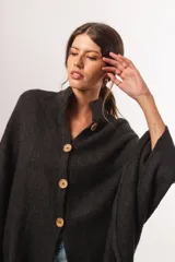 Capa de lana merino color gris oscuro con cuello alto y cierre frontal con botones de madera.