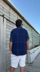 Camisa de manga corta con estampado abstracto en tonos azules, verdes y rojos.