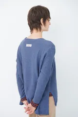Sweater de punto en color azul, con escote en V, mangas largas y corte holgado con ruedo asimétrico.