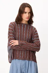 Sweater de punto con diseño de rayas verticales en relieve y textura trenzada, color terracota y beige. Presenta cuello redondo, corte holgado y diseño cropped.