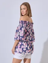 Blusa de gasa estampada con flores rosas y verdes sobre fondo azul marino. Escote bote con punto smock y mangas cortas amplias.