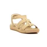 Sandalias de cuero color beige con diseño de tiras cruzadas en el empeine y pulsera con elástico en el tobillo. Poseen suela baja de goma con textura acanalada y plantilla acolchada.