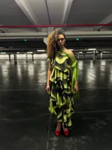 Vestido midi con estampado abstracto en tonos verde lima y negro, con cuello alto y volantes en la falda.