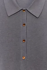 Chaqueta de punto gris oscuro, de manga larga, con cuello solapa y cierre frontal de botones dorados.