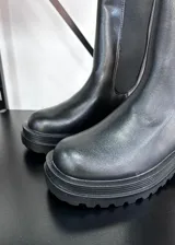 Botas Chelsea de caña media color negro, con elásticos laterales y suela track. Fabricadas en cuero vegano.