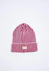 Gorro de tejido de punto con diseño a rayas verticales en color rojo y rosado, con doblez y parche de cuero sintético con logo de la marca en el frente.
