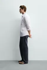 Camisa regular fit de manga larga con diseño a rayas verticales celestes y blancas. Cuenta con cuello abotonado, bolsillo de parche en el pecho y cierre frontal con botones.