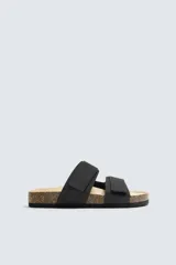 Sandalias negras con suela de corcho y doble tira con velcro ajustable.