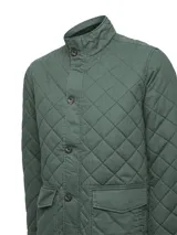 Chaqueta acolchada de algodón orgánico color verde militar, de estilo clásico inglés con diseño de rombos. Presenta cuello alto, cierre frontal con broches metálicos, bolsillos frontales con solapa y bolsillos interiores. Cuenta con relleno de THERMORE fabricado con fibras recicladas.