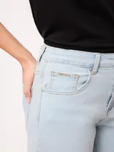 Short de denim elastizado de tiro alto, color beige, con bolsillos delanteros y traseros, y cierre frontal con botón y cremallera.