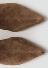 Botines de gamuza color marrón con taco fino y punta afilada, diseñados con caña corta y cierre lateral.