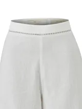 Pantalon de corte recto y tiro alto, confeccionado en una mezcla de lino orgánico y viscosa. Presenta detalles de calado decorativo en la cintura y en el ruedo de las piernas.