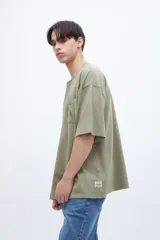 Remera verde oliva teñida en prenda con bolsillo en el pecho, de algodón lavado con textura extra suave y calce boxy.