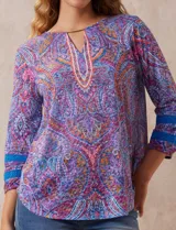 Blusa estampada de la marca Ruby Rd. Tiene cuello redondo, escote en V con aplique metálico y mangas ¾ con aplique de crochet.