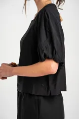 Blusa marrón de mangas cortas abullonadas, cuello redondo y diseño holgado.
