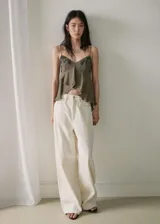 Top de tirantes finos color verde militar, con escote en V, apliques bordados con micro abalorios y detalle de volantes asimétricos.