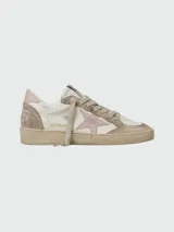 Championes Golden Goose modelo Ballstar, de cuero blanco con detalles en gamuza beige y estrella lateral en color rosa. Presentan un diseño desgastado característico de la marca, con cordones al tono y etiqueta con logo en la lengüeta.