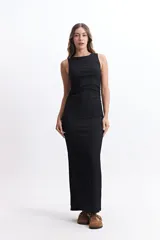 Vestido largo sin mangas con escote cerrado y silueta ajustada. Confeccionado en tela liviana con textura, presenta un diseño versátil y cómodo que se adapta al cuerpo.