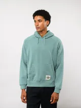 Canguro de felpa color verde menta, con capucha, bolsillo canguro frontal y etiqueta del logo Umbro en la parte delantera.