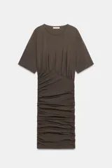 Vestido corto de manga corta y cuello redondo, confeccionado con mezcla de algodón. Presenta un diseño ajustado con drapeado lateral en la falda.