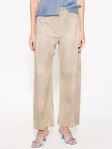 Pantalón ancho de cuero ovino color beige, con recortes verticales y horizontales, bolsillos delanteros tipo jean y bolsillos traseros tipo parche.