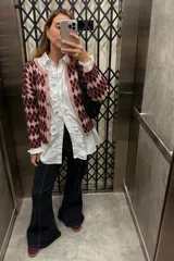 Saco tejido con diseño de rombos en tonos bordó y rosado, con cierre frontal de botones y cuello redondo.