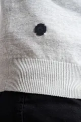 Buzo gris jaspeado de tejido de punto, con medio cierre frontal, cuello alto, manga larga y logo en goma. Corte regular.