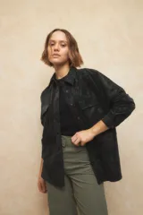 Sobrecamisa de efecto engomado en color negro, con textura lavada, cuello clásico, cierre frontal con botones a tono y bolsillos frontales con solapa.