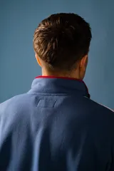 Buzo de felpa con medio cierre, diseño a bloques de color azul, blanco y rojo.